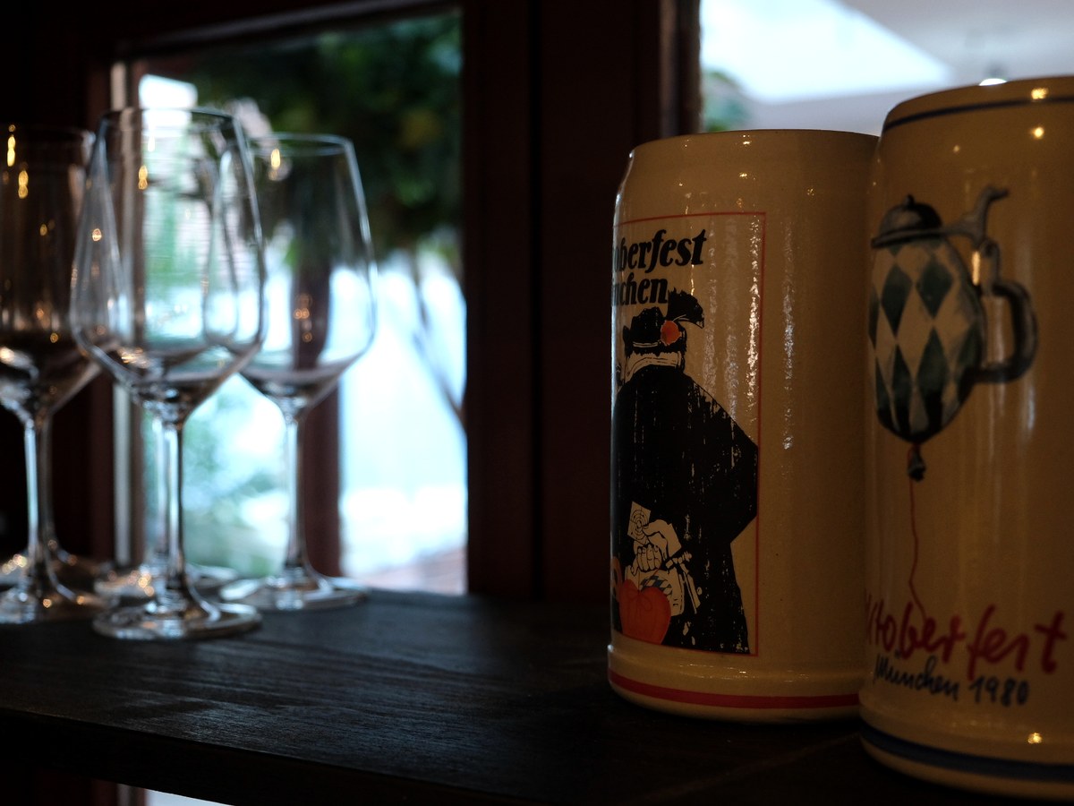 Weingläser und bayerische Bierkrüge auf der Bar-Ablage
